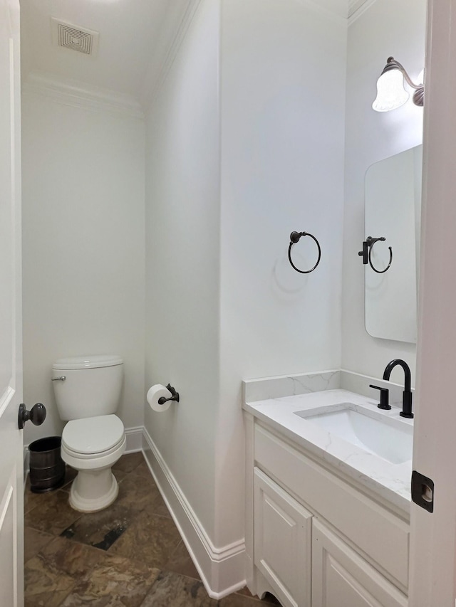 half bathroom featuring vanity, baseboards, visible vents, ornamental molding, and toilet