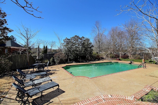 view of pool featuring a diving board, a fenced in pool, a patio area, and fence