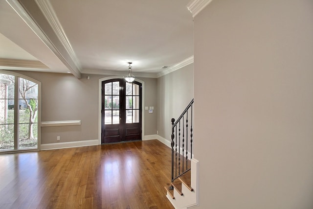 foyer entrance featuring french doors, plenty of natural light, ornamental molding, and hardwood / wood-style flooring