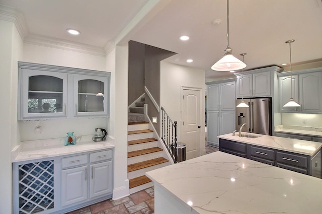 kitchen featuring gray cabinets, stone tile floors, recessed lighting, crown molding, and high end refrigerator