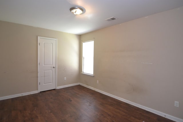 unfurnished room with visible vents, baseboards, and wood finished floors