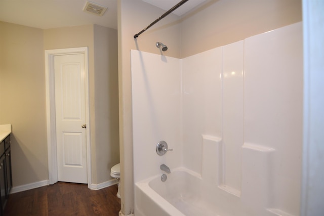 bathroom with vanity, wood finished floors, visible vents, bathtub / shower combination, and toilet