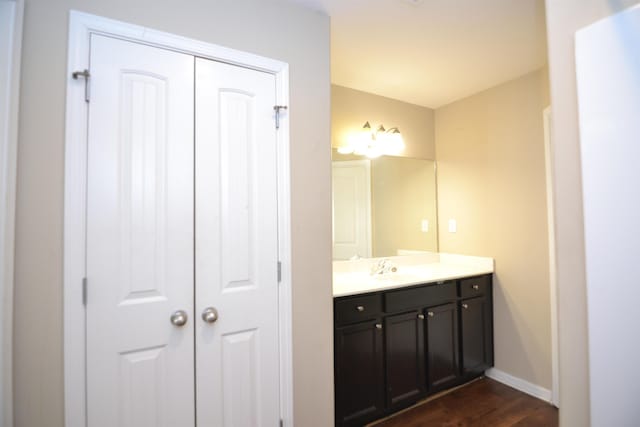 bathroom featuring vanity, baseboards, and wood finished floors