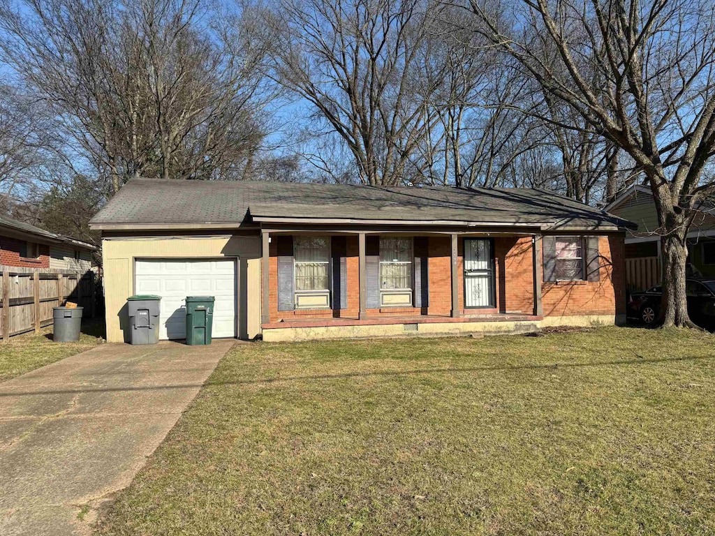 ranch-style house with driveway, fence, a front yard, an attached garage, and brick siding