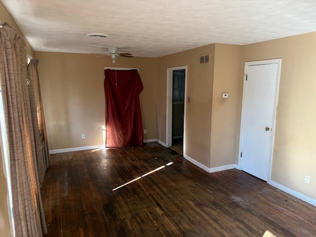 unfurnished room with wood finished floors, visible vents, and baseboards