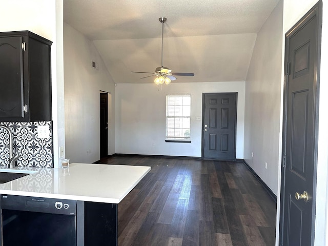 interior space with dark cabinetry, lofted ceiling, dark wood-style flooring, light countertops, and black dishwasher