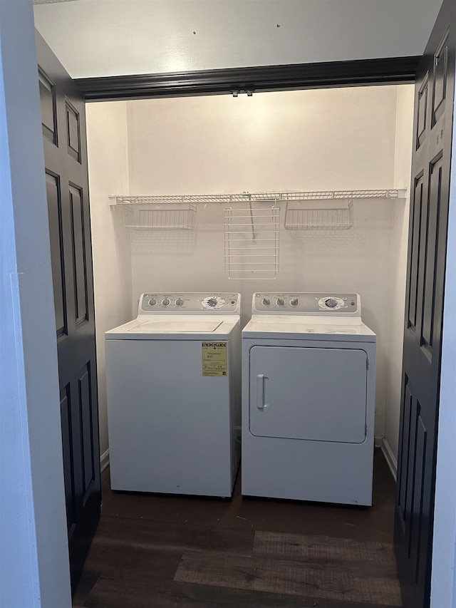 clothes washing area with dark wood finished floors, laundry area, and separate washer and dryer