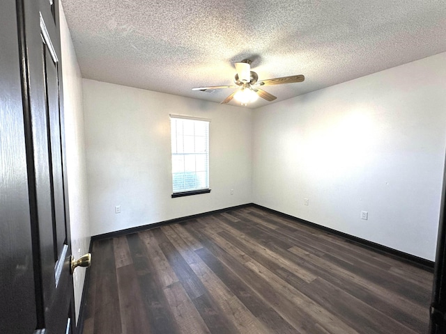 empty room featuring visible vents, a ceiling fan, a textured ceiling, dark wood-style floors, and baseboards