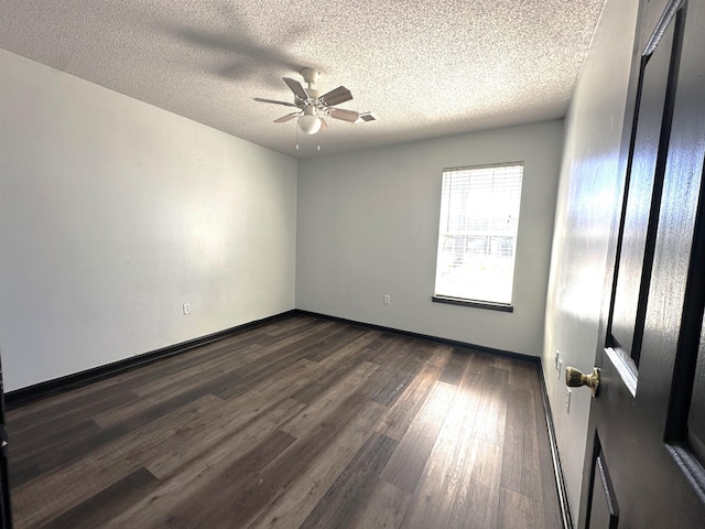 unfurnished room with baseboards, a ceiling fan, dark wood-style flooring, and a textured ceiling