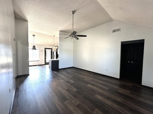 unfurnished living room with visible vents, dark wood finished floors, lofted ceiling, ceiling fan, and a textured ceiling