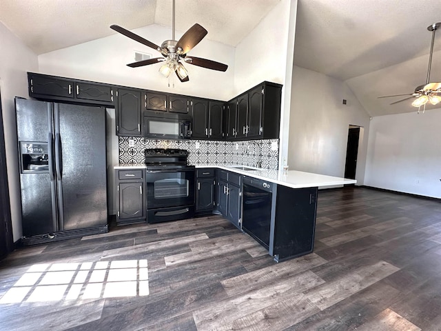 kitchen featuring dark wood-type flooring, light countertops, a peninsula, black appliances, and a ceiling fan