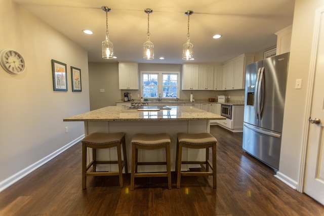 kitchen featuring a kitchen island, stainless steel appliances, dark wood-type flooring, and baseboards