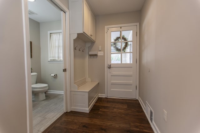 mudroom featuring dark wood-type flooring, visible vents, and baseboards