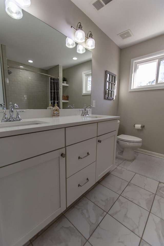 bathroom featuring visible vents, toilet, a tile shower, marble finish floor, and a sink