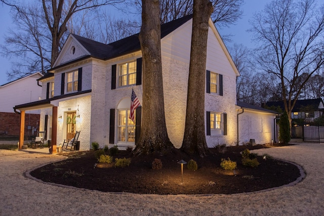 view of front of house with brick siding and fence