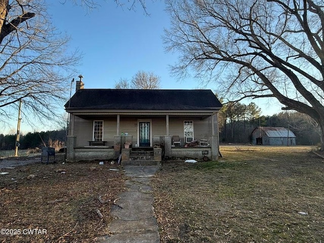 bungalow-style home featuring a porch and a chimney