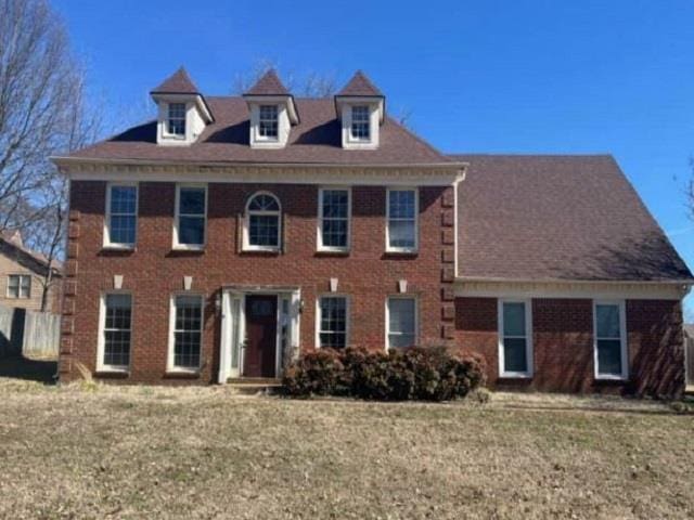 view of front facade featuring brick siding and a front lawn