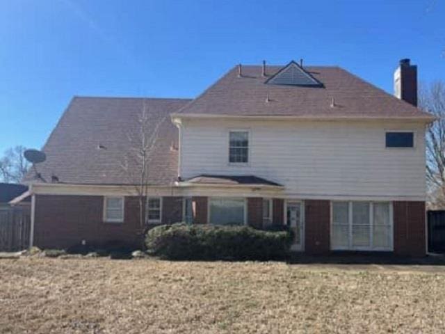 rear view of property featuring a chimney