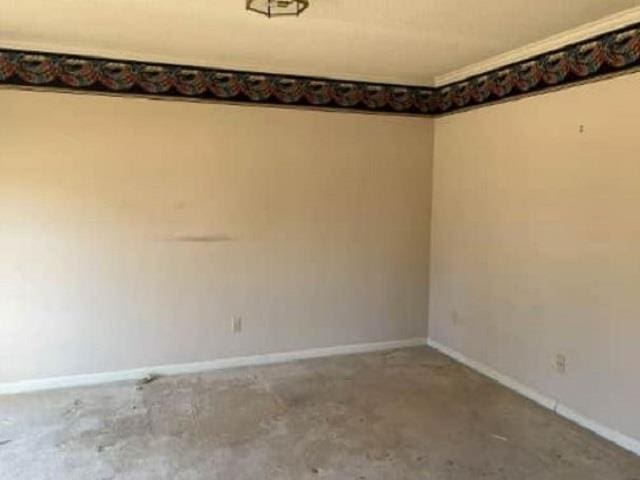 empty room featuring baseboards and concrete floors