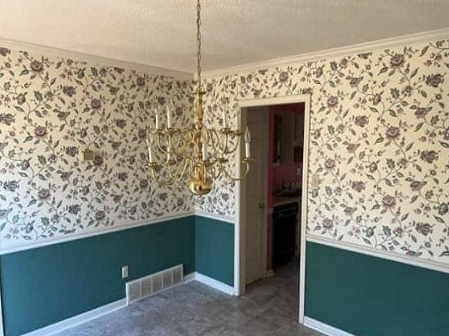 spare room with a wainscoted wall, visible vents, crown molding, and wallpapered walls