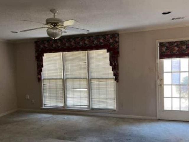 unfurnished room with baseboards, a healthy amount of sunlight, and crown molding