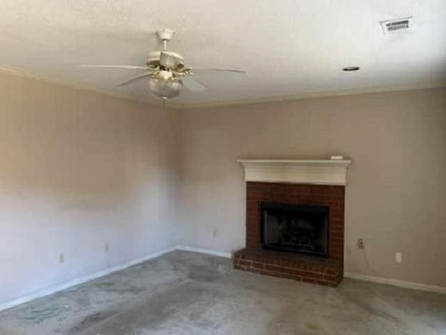 unfurnished living room featuring a brick fireplace, baseboards, visible vents, and ceiling fan