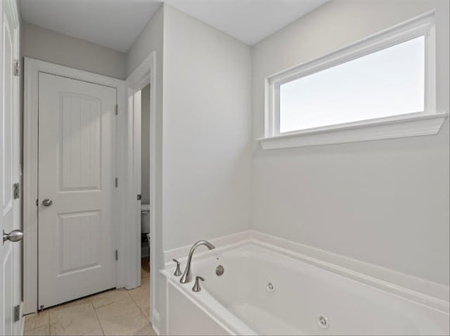 full bath featuring a whirlpool tub and tile patterned flooring