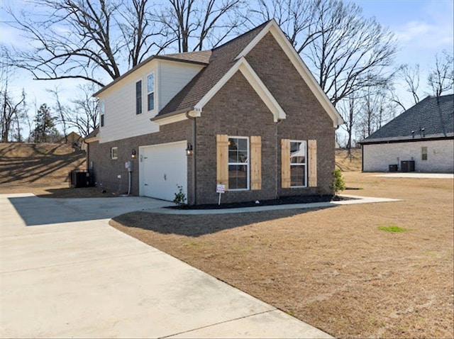 view of front of property featuring brick siding, an attached garage, central air condition unit, a front yard, and driveway