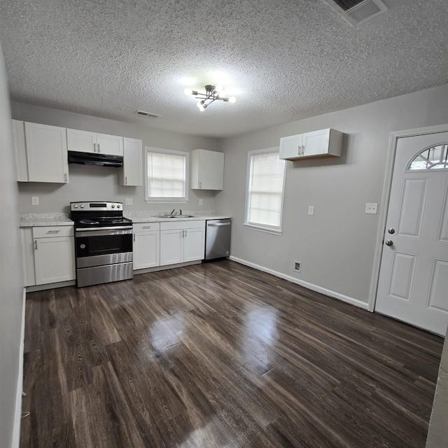 kitchen with visible vents, under cabinet range hood, dark wood finished floors, light countertops, and appliances with stainless steel finishes