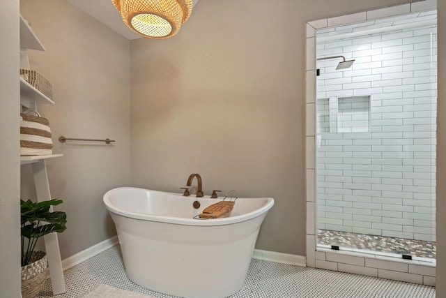 full bathroom featuring tile patterned flooring, a soaking tub, a shower stall, and baseboards