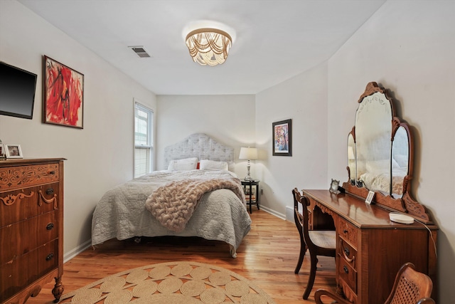 bedroom featuring light wood-type flooring, visible vents, and baseboards