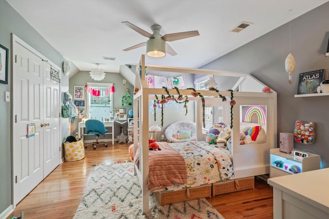 bedroom featuring lofted ceiling, wood finished floors, visible vents, and ceiling fan