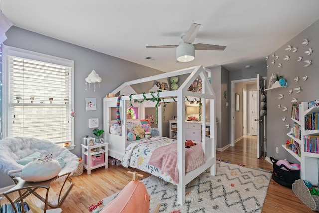 bedroom with visible vents, a ceiling fan, and wood finished floors