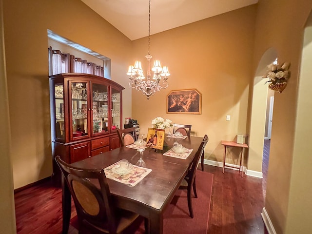 dining space featuring dark wood-style floors, a chandelier, and baseboards