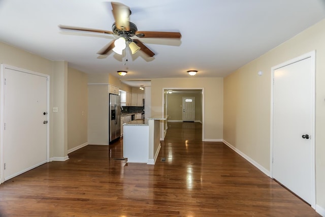 kitchen featuring baseboards, stainless steel fridge, dark wood-type flooring, and white cabinets