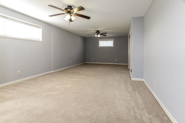 unfurnished room featuring light carpet, ceiling fan, and baseboards