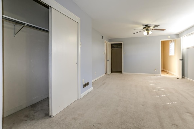 unfurnished bedroom with light carpet, a closet, and baseboards