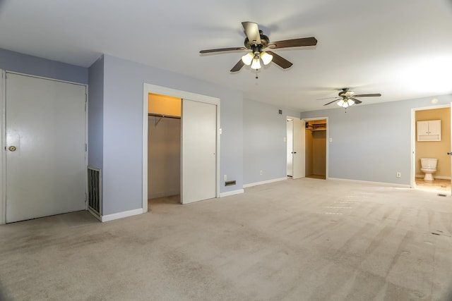 unfurnished bedroom with light carpet, connected bathroom, baseboards, and ceiling fan