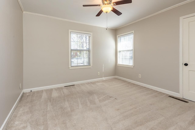 spare room featuring baseboards, visible vents, ceiling fan, ornamental molding, and light carpet