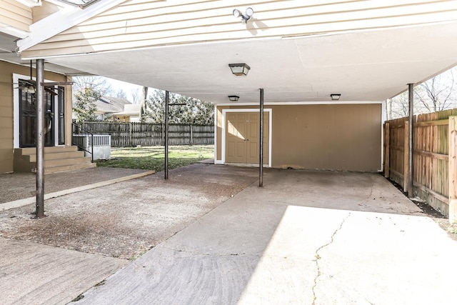 exterior space featuring entry steps, a carport, and fence