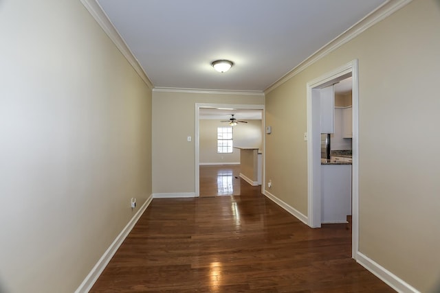 hall featuring crown molding, baseboards, and wood finished floors