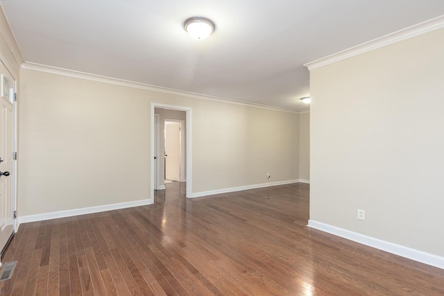 spare room featuring visible vents, crown molding, baseboards, and wood finished floors