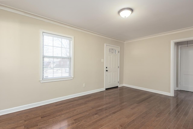 empty room featuring crown molding, baseboards, and dark wood-type flooring