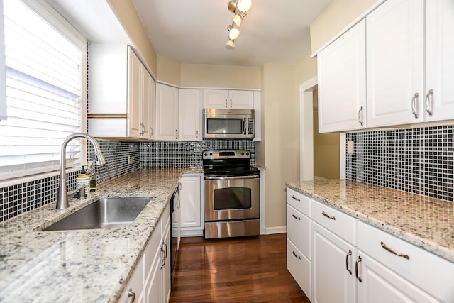 kitchen with a sink, tasteful backsplash, dark wood-style floors, white cabinetry, and stainless steel appliances