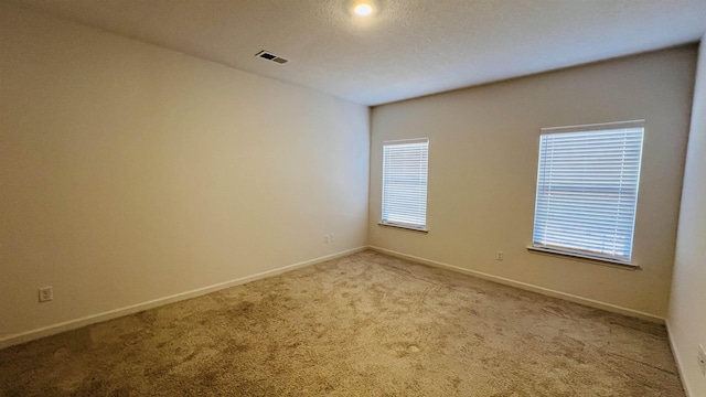 unfurnished room featuring carpet flooring, baseboards, and visible vents