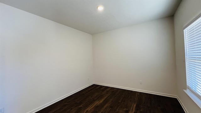 empty room with baseboards and dark wood-style flooring