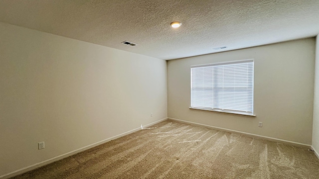 spare room with visible vents, baseboards, and light colored carpet