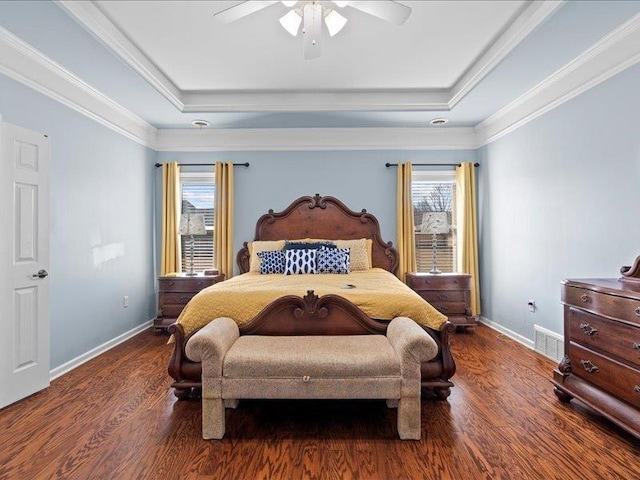 bedroom featuring multiple windows, a tray ceiling, and dark wood-style flooring