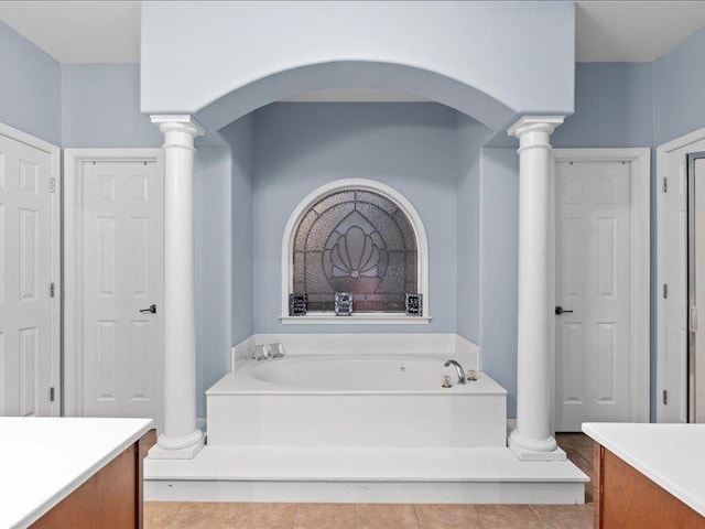 full bath with decorative columns, a bath, and vanity