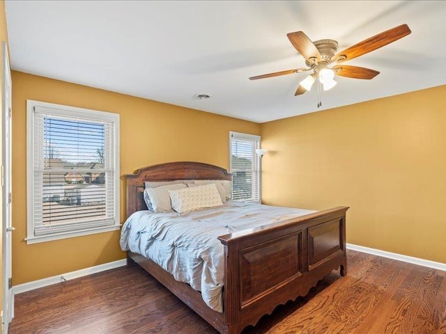 bedroom with visible vents, wood finished floors, baseboards, and ceiling fan